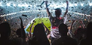 Fans celebrate in a packed stadium with confetti falling