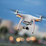 Quadcopter drone with camera flying outdoors