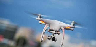Quadcopter drone with camera flying outdoors