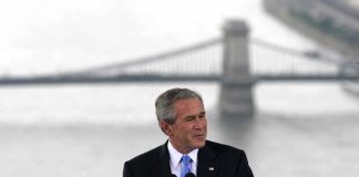 Shocking Move: Bush’s Message to Muslims George W. Bush speaking at a podium with a bridge over water in the background