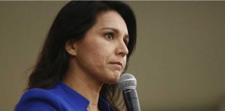 Tulsi Gabbard speaking into a handheld microphone
