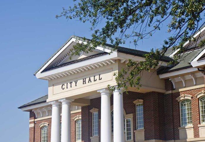 shutterstock_100049108 Exterior view of a city hall building with columns and a clear blue sky