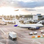 Missile Strikes Kill 3 at Saudi Airport Airplanes at airport gates during sunset with ground vehicles and jet bridges