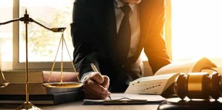 DOJ Moves to Block 20,000 California Ballots Lawyer writing at desk with scales and gavel