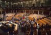 Legislative chamber with members gathering on the floor