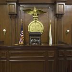 Federal Judge Faces Rare Misconduct Probe Interior of a courtroom featuring a judges bench and American flag