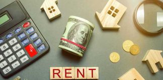 Rent payment concept with calculator, cash roll, coins, keys, and wooden house icons