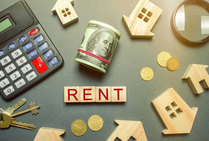 shutterstock_1288041718 Rent payment concept with calculator, cash roll, coins, keys, and wooden house icons