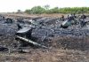 Airplane crash debris scattered across a burned field