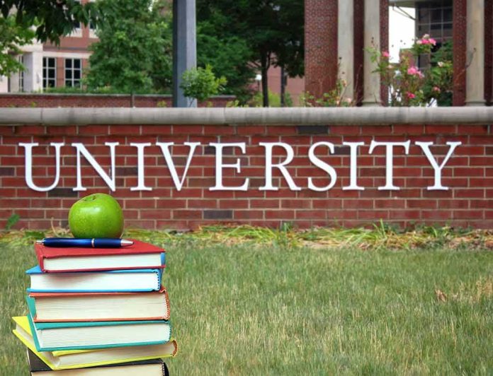 shutterstock_141582367 Stack of books with apple in front of university sign