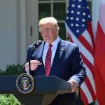 Diesel Shock: Trump Targets Rising Fuel Costs Donald Trump speaking at a podium with U.S. and Polish flags behind him