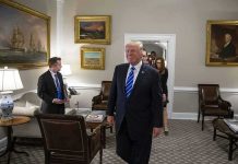 Donald Trump walks through an office with Sean Lawler nearby and Mariano Rajoy following behind