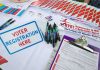 Voter registration table with forms, pens, and informational materials