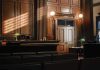 Empty courtroom interior with wooden judge's bench and double doors