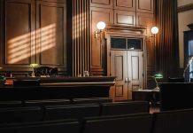Empty courtroom interior with wooden judge's bench and double doors