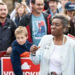 Woman addressing a crowd at an outdoor event