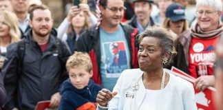 Woman addressing a crowd at an outdoor event