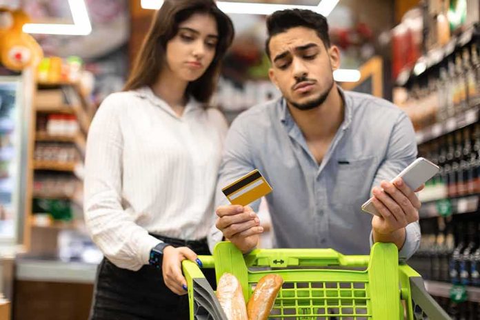 Couple with shopping cart checks credit card and phone