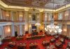 Legislative chamber with red carpet and chandeliers