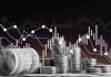 Stacks of coins and rolled dollar bills with falling financial charts