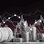 Stacks of coins and rolled dollar bills with falling financial charts
