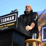 California Could See a Radical Tax Overhaul Speaker at outdoor podium with campaign signs