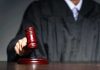 Judge with gavel striking sound block
