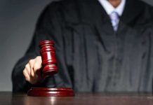 Judge with gavel striking sound block