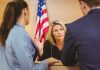 Judge speaking with two attorneys at the bench in a courtroom