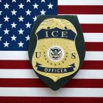 Training Delays Slow Immigration Enforcement ICE officer badge on American flag background