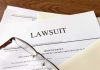 Legal documents labeled lawsuit on a desk