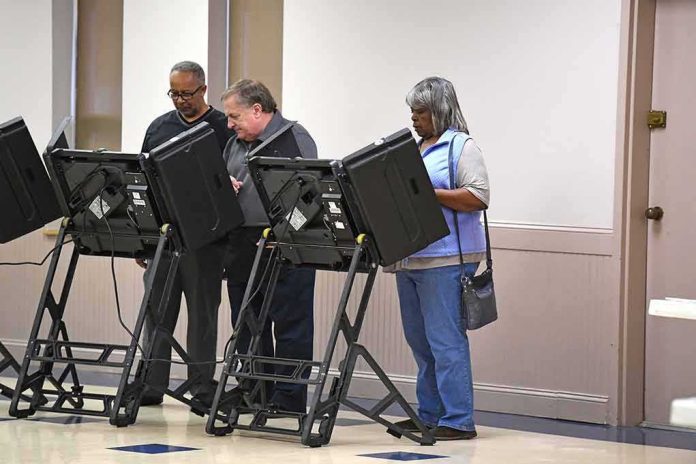 shutterstock_512226370-1 Lester Bowie and Miriam Tlali using electronic voting machines at a polling place