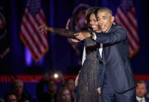 Michelle Obama and Rob Nabors pointing on stage at an event