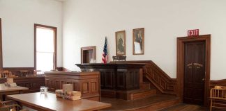 Victim Stunned: Judge Dismisses Toxic Poisoning Case Interior of a historic courtroom with wooden furniture and an American flag