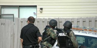 Teen Arrested After Fresno Nightclub Shooting police officers in tactical gear beside patrol car