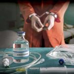 Execution Ends Without Death Medical vials and IV lines on a table with a handcuffed person in the background