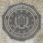 Federal Agents Search Lawmaker’s Home FBI seal on a granite wall