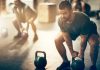 Man lifting kettlebell in a gym setting