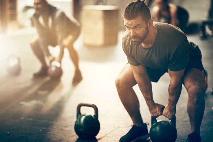 1043370892 featured image Man lifting kettlebell in a gym setting