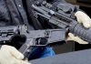 Person assembling a rifle with gloved hands