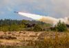 Military tank firing a missile in forest area