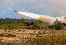 Military tank firing a missile in forest area
