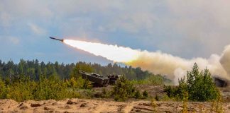 Military tank firing a missile in forest area