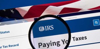 Magnifying glass over IRS website paying taxes