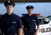 Two police officers standing near patrol car