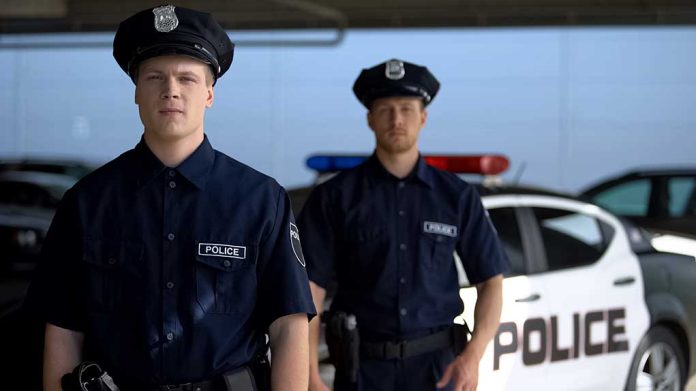 1492496696 featured image Two police officers standing near patrol car