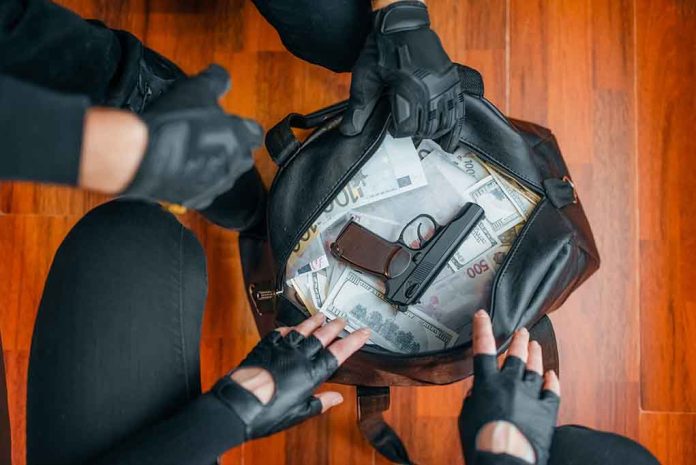 1504435784 featured image Gloved hands around bag with money and gun