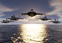 Five fighter jets flying over the ocean