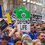 Pro-life rally with people holding various signs
