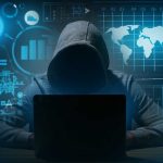 Hacker in hoodie using laptop with digital graphs